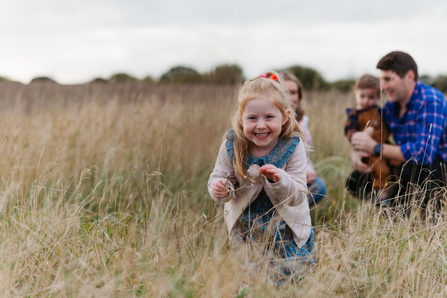 People enjoying a playful moment together while lying in tall grass outdoors. Photographer. Hull. East Yorkshire. Photography