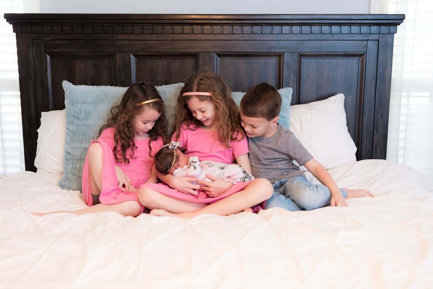 Siblings enjoying their new baby sister.