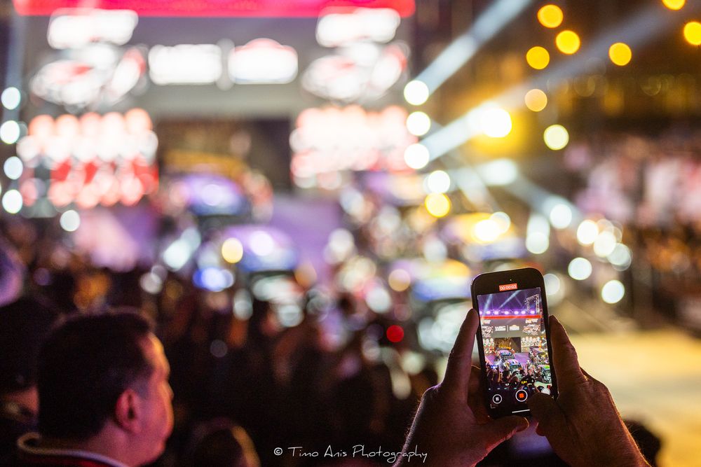 Blurry nighttime street scene with illuminated bars and bright neon lights creating a vibrant atmosphere.