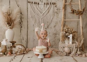 A collection of vintage-inspired pastel party decorations and dessert displays arranged in a rustic beige setting.