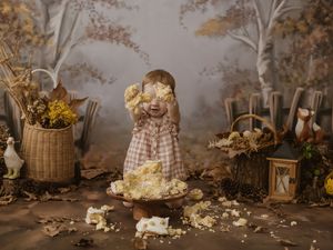 Atmospheric fall photo shoot setup with vintage baskets, plaid blankets, pumpkins and dried florals in muted tones.