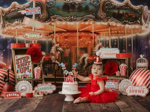 Vintage carousel with circus-themed decorations and red and white striped popcorn boxes in carnival setting.