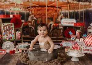 Rustic party table setup with red and white decorations, vintage carnival theme, popcorn containers and festive banners.