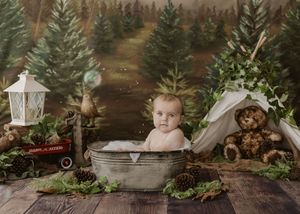 Adorable baby sitting in vintage metal tub with bubbles surrounded by woodland themed photography props.
