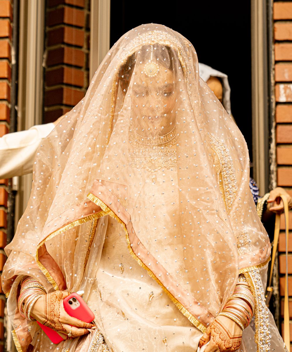 Traditional bridal ensemble featuring detailed veil and gold-trimmed outfit.