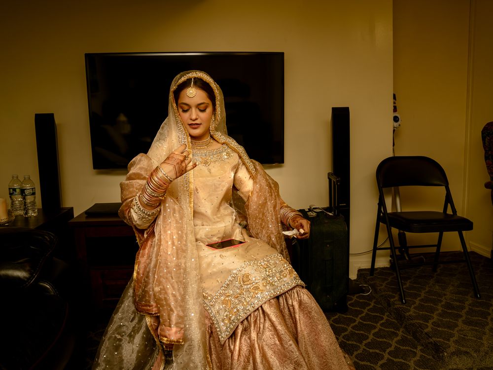 Elegant bridal preparations captured in a dimly lit indoor setting with traditional decor.