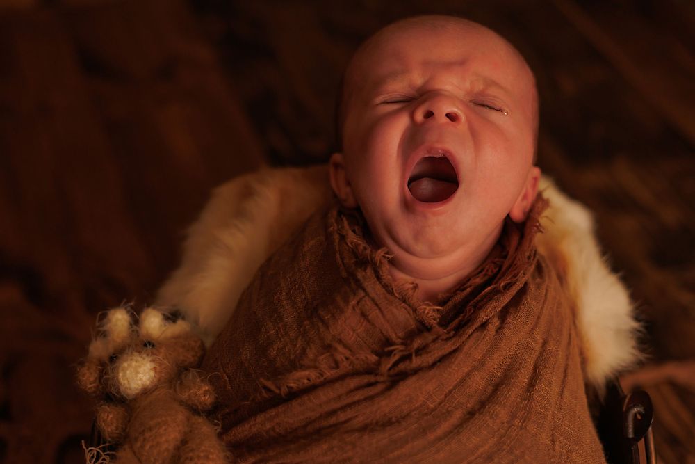 Artistic portrait of sleeping newborn in warm sepia tones.