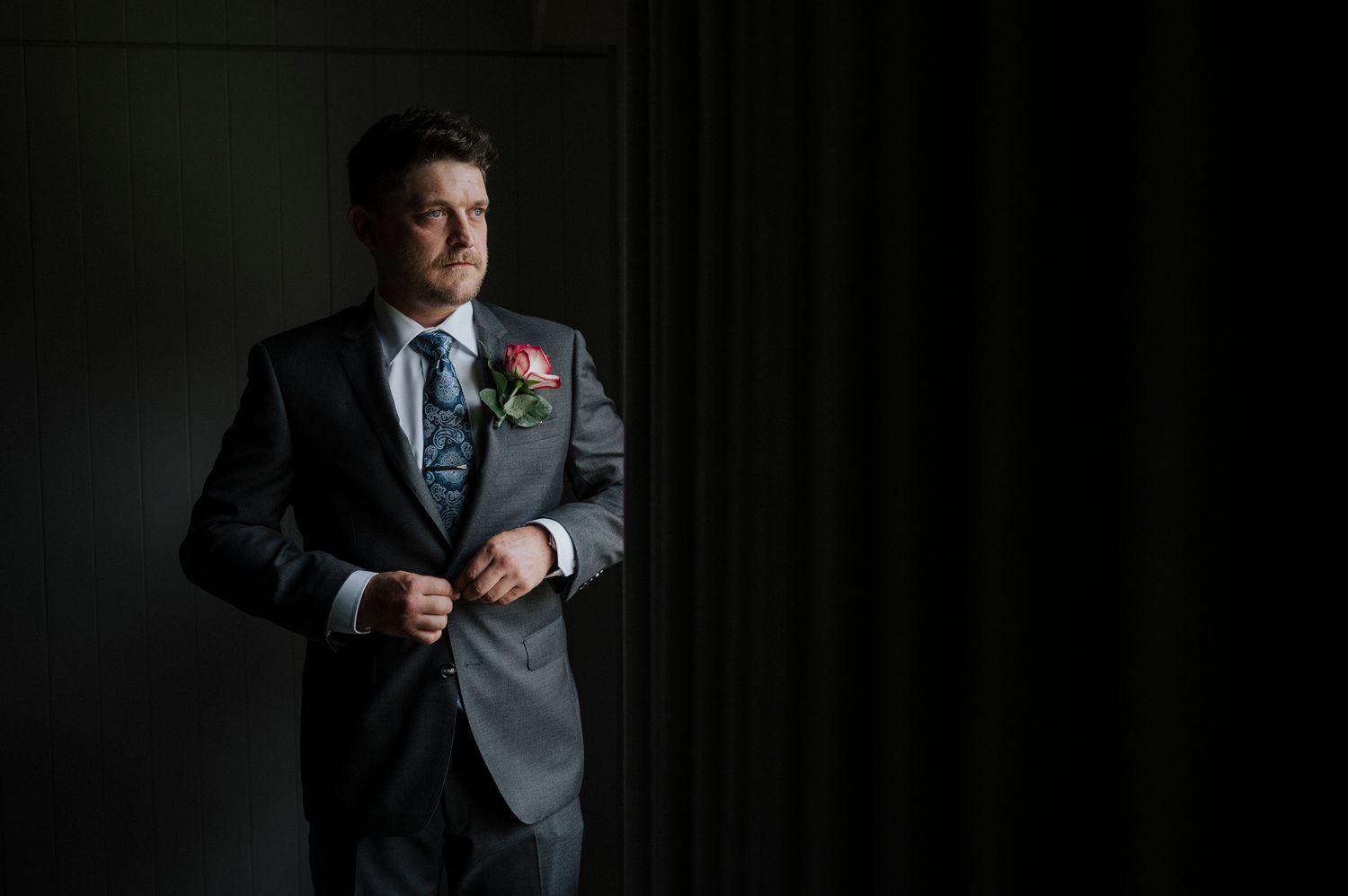 A series of headshots in formal attire showing different expressions against a dark background.