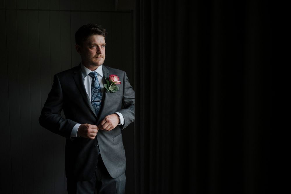 A series of headshots in formal attire showing different expressions against a dark background.