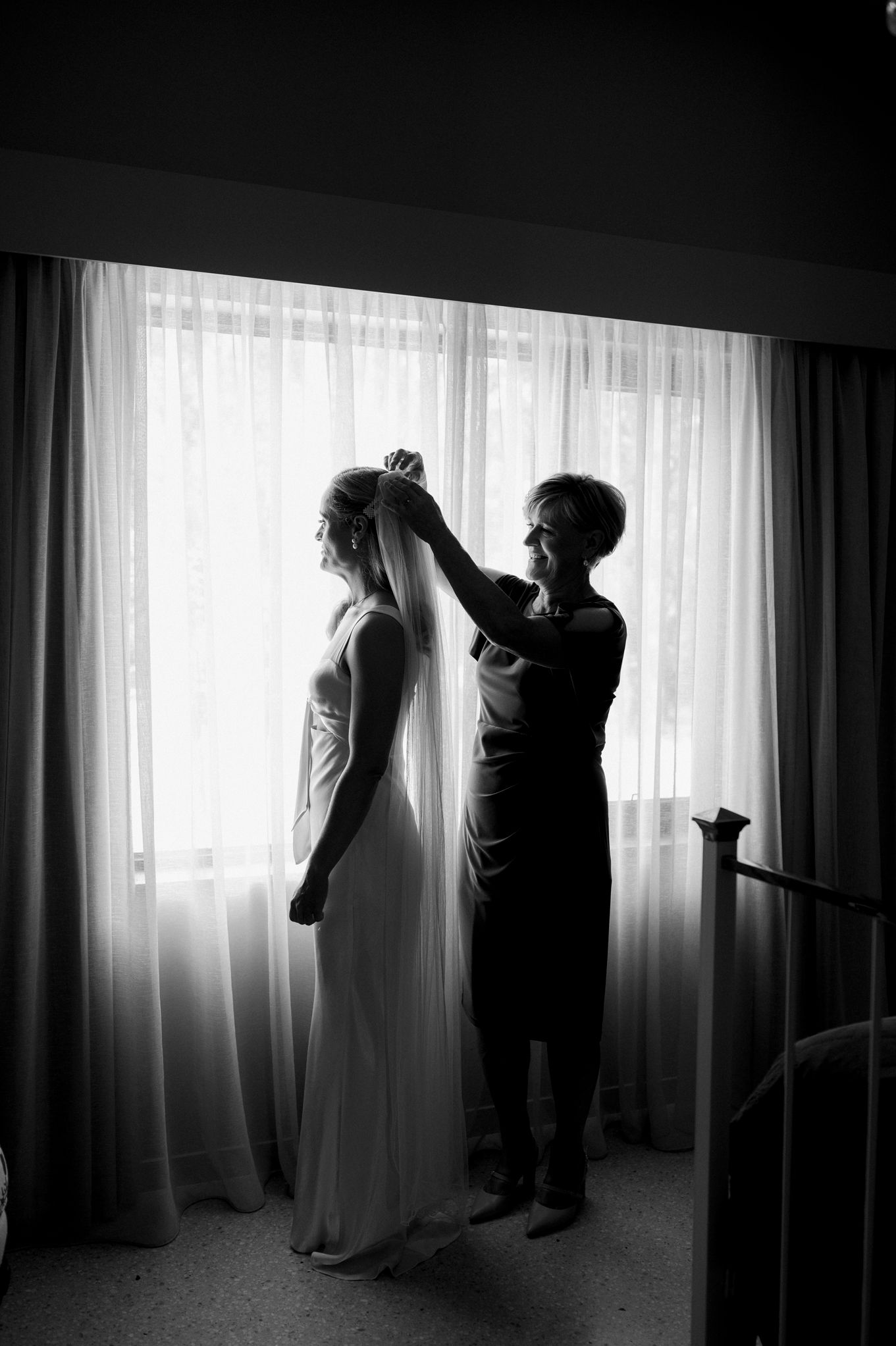 A series of moody black and white silhouettes show two people against a bright window with sheer curtains.