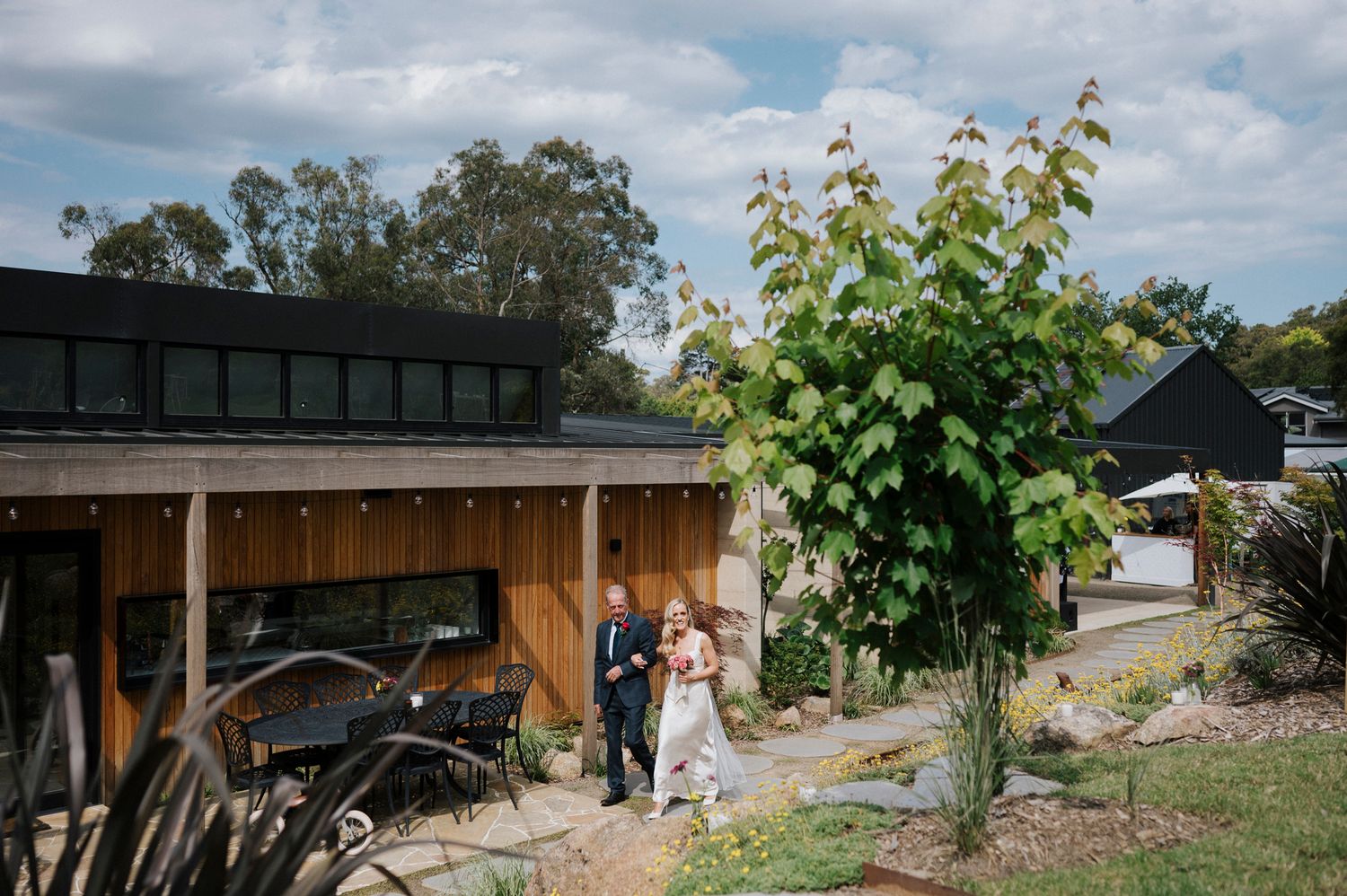 Rustic barn wedding venue with scenic countryside views and wooden architectural details under cloudy skies.