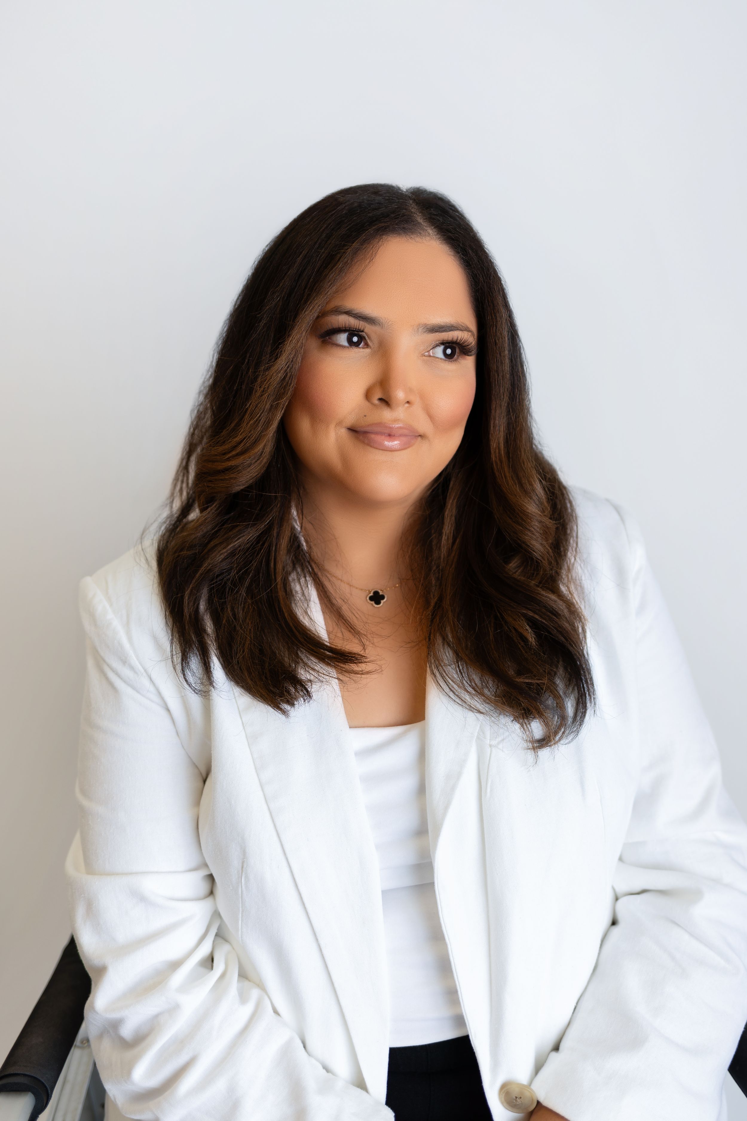 Professional headshot of small business owner with neutral backdrop and natural lighting.