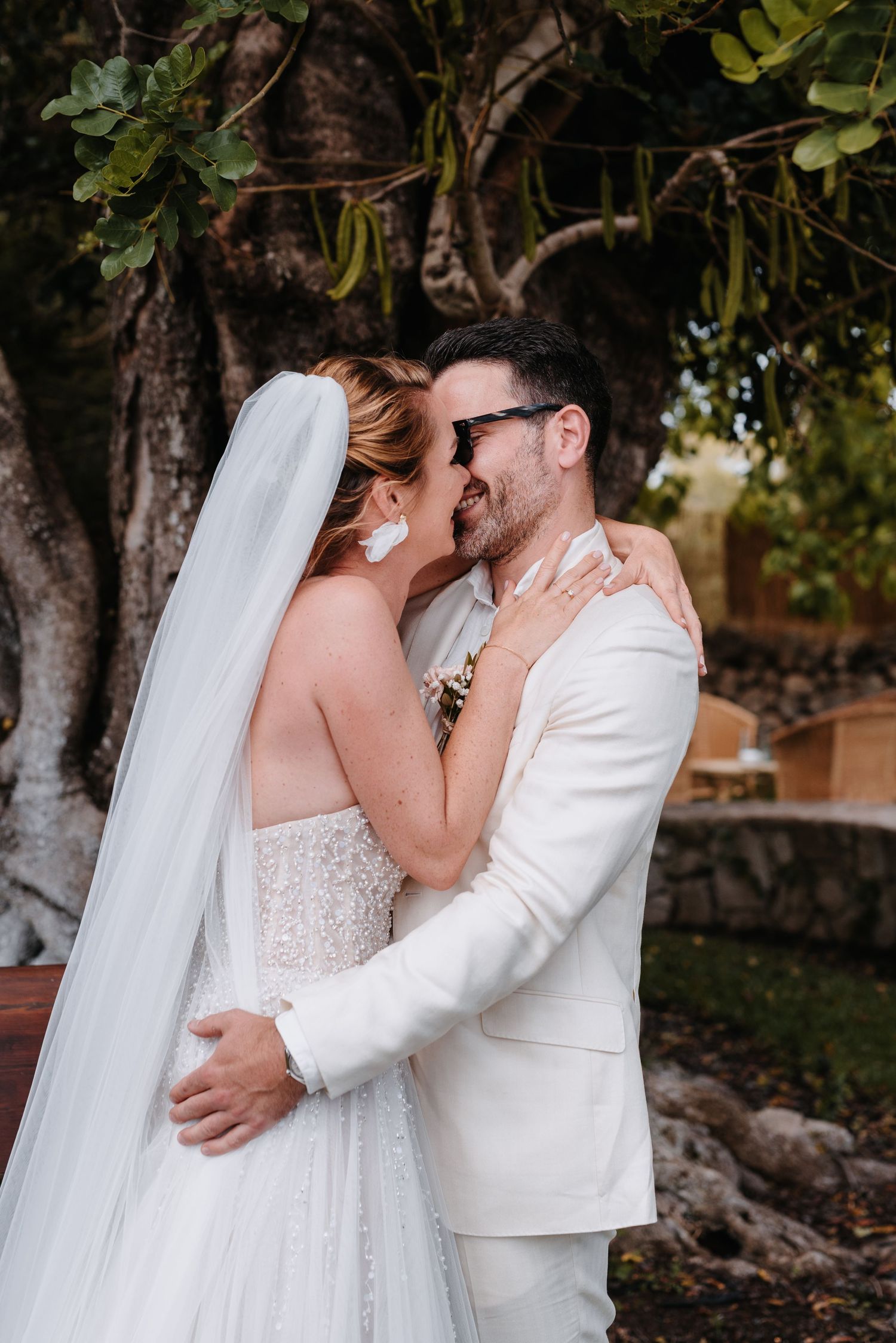 Ein romantischer Moment inmitten der Natur, eingefangen bei einer Mallorcahochzeit im Freien, mit dem Brautpaar in weißer Hochzeitskleidung.