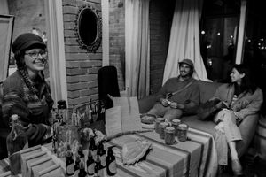 Group gathered around a table with books and refreshments in a brick-walled room during casual social event.