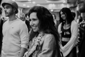 Concert attendees smile and enjoy a performance in a crowded venue.