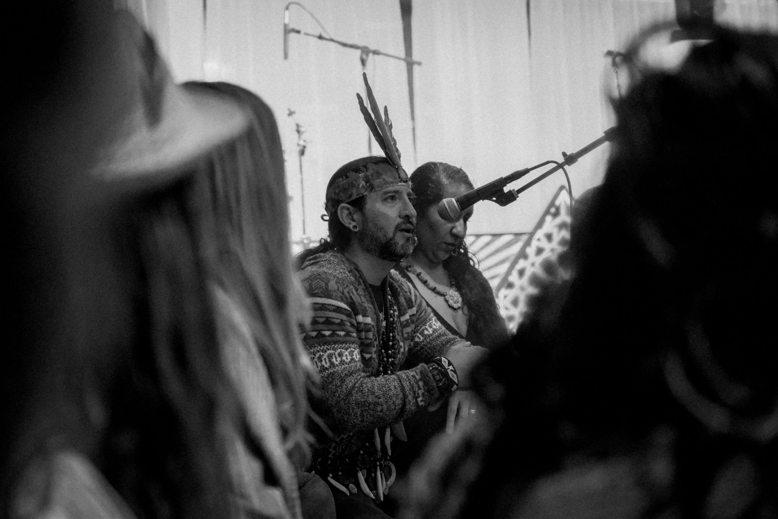 People gathered closely together in an animated discussion captured in black and white.