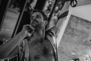 A performer in black and white contemplates during an aerial arts performance.