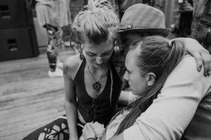 Two people share an intimate conversation in black and white, creating a candid documentary-style moment.