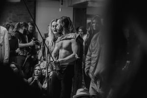 An intimate black and white shot of performers preparing backstage for an aerial arts show.