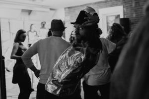 People gathered in what appears to be a dance or exercise class in a brick-walled room.