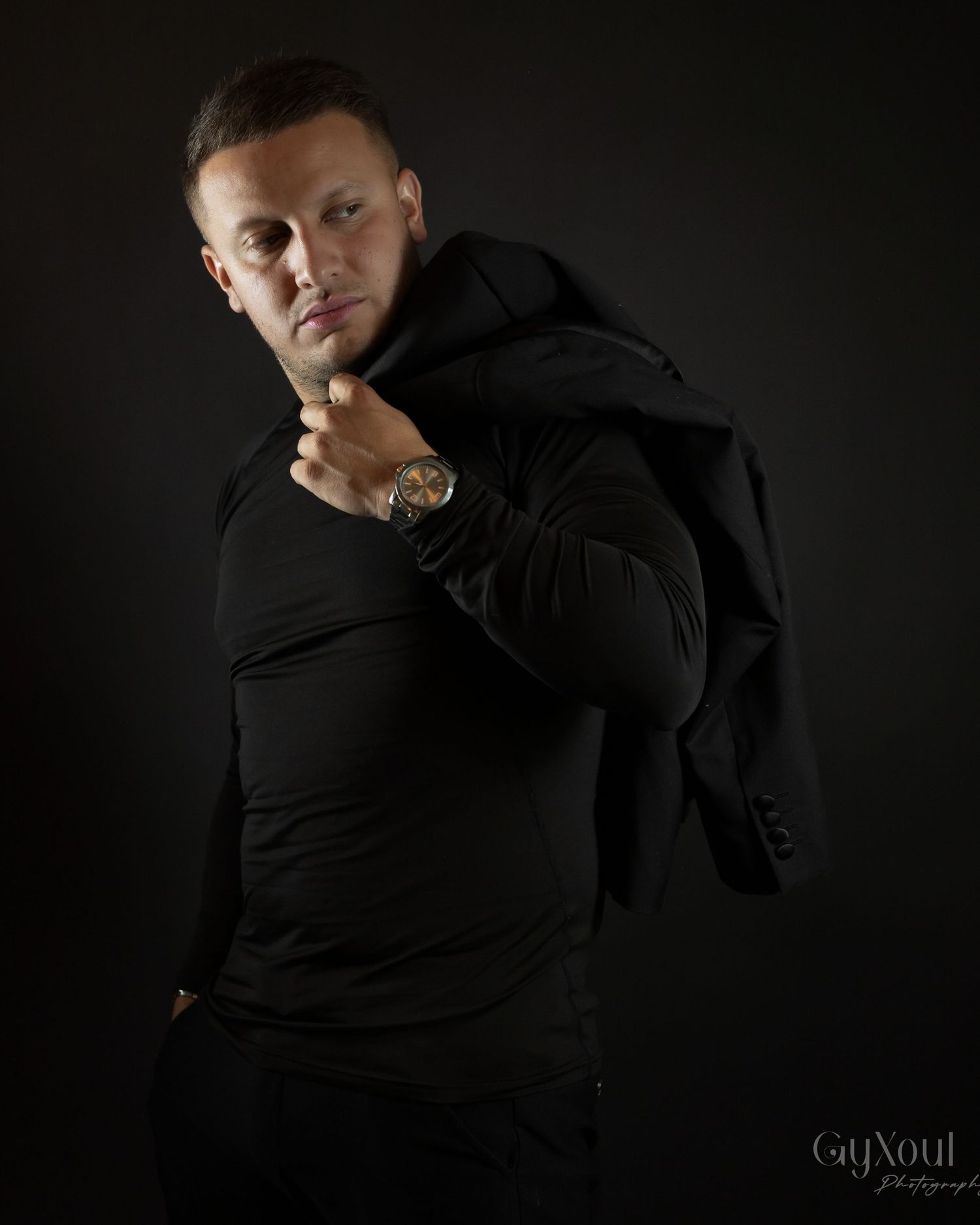 A dramatic photo series against a black background showcases various moody poses in black clothing.