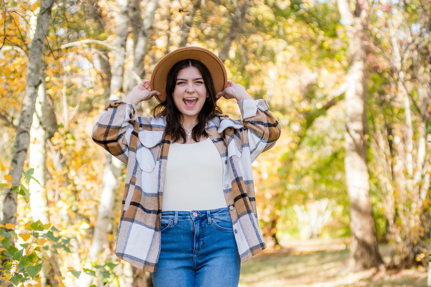 Casual autumn portrait session featuring natural poses among fall foliage.