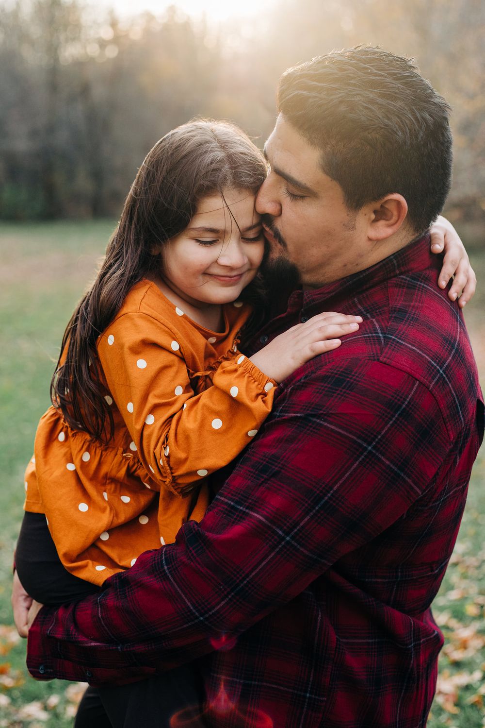 father holds daughter at golden hour