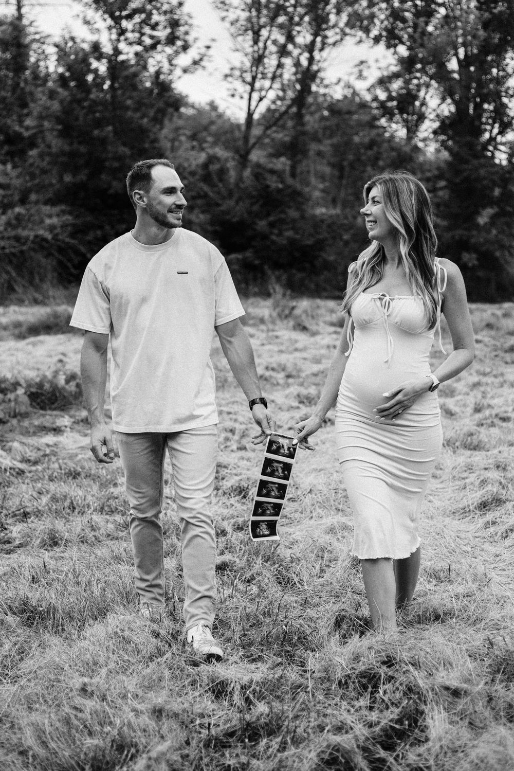couple holds ultrasound photos