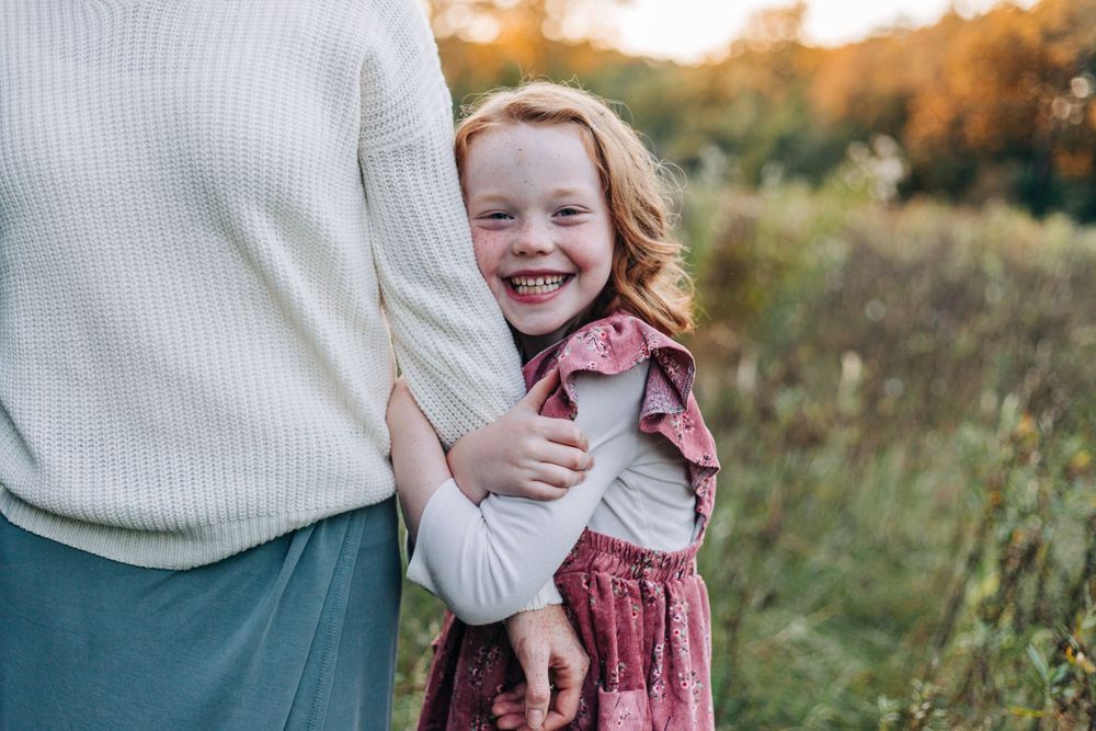 girl smiles at camera in field