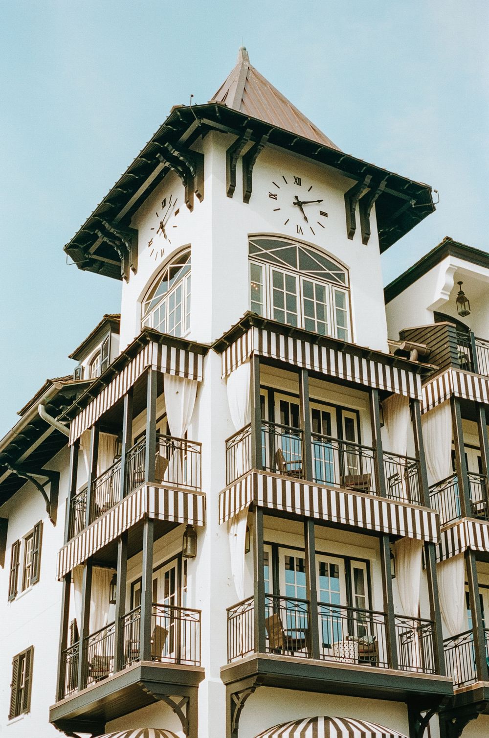 Architecture detail of a classic white and brown Victorian style hotel with multiple balconies and ornate trim details.