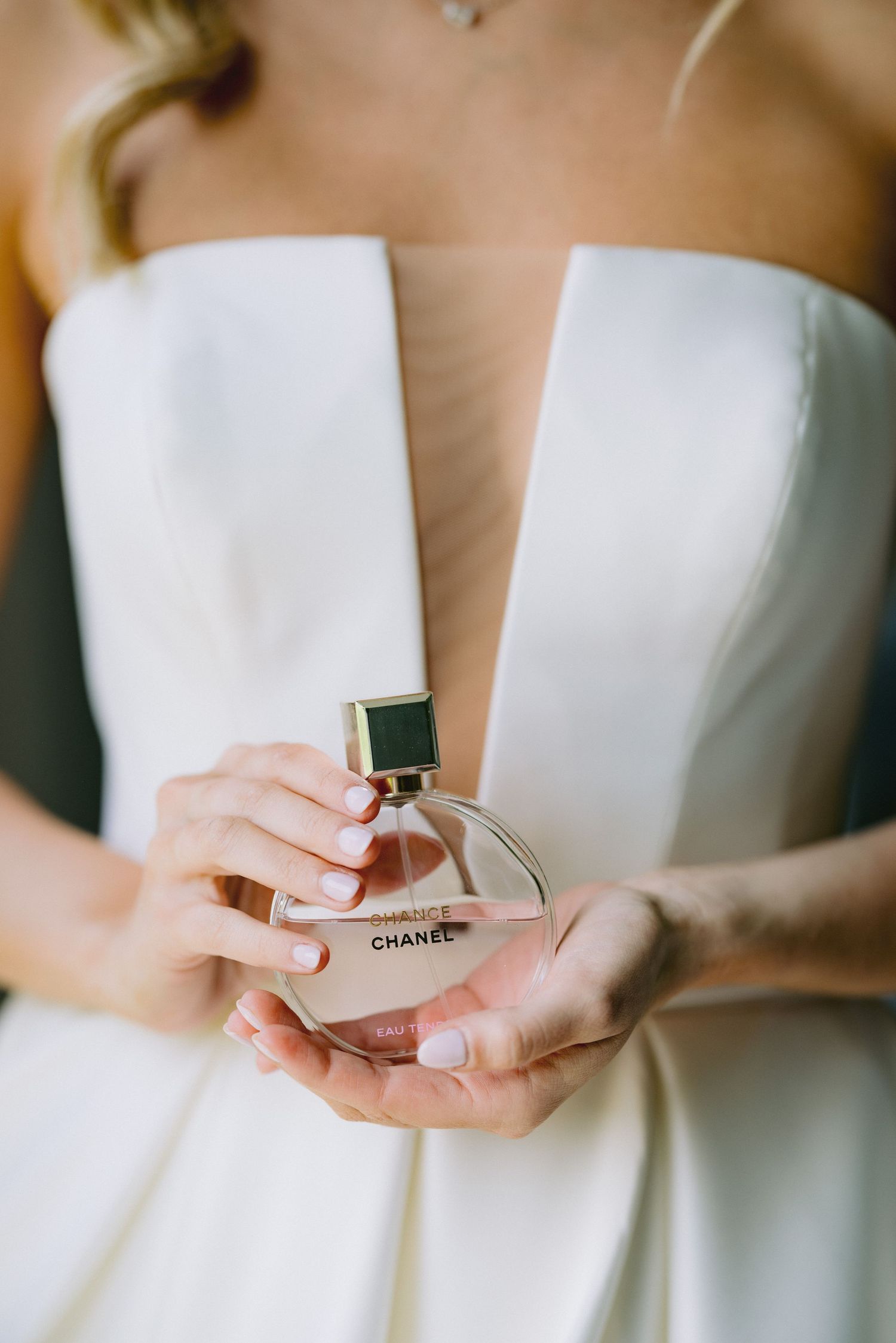 Bridal Detail | Dayton Wedding Photographer | Close-up shots showing hands holding a Chanel perfume bottle in elegant white wedding attire.