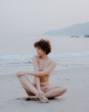 Dreamy beachside portrait with soft focus and muted color tones.