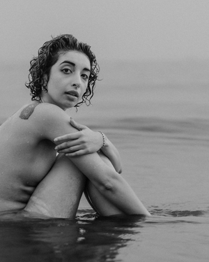 Moody black and white portrait taken in calm waters during overcast conditions.