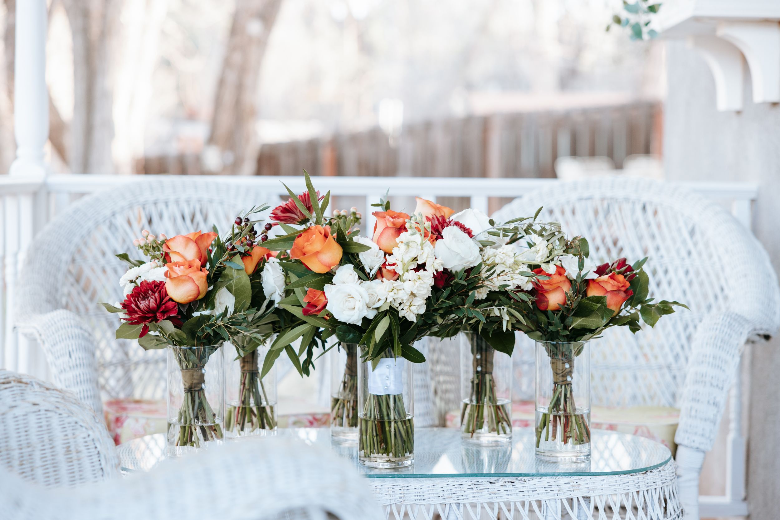 Wedding reception table decorations featuring floral centerpieces in glass vases.