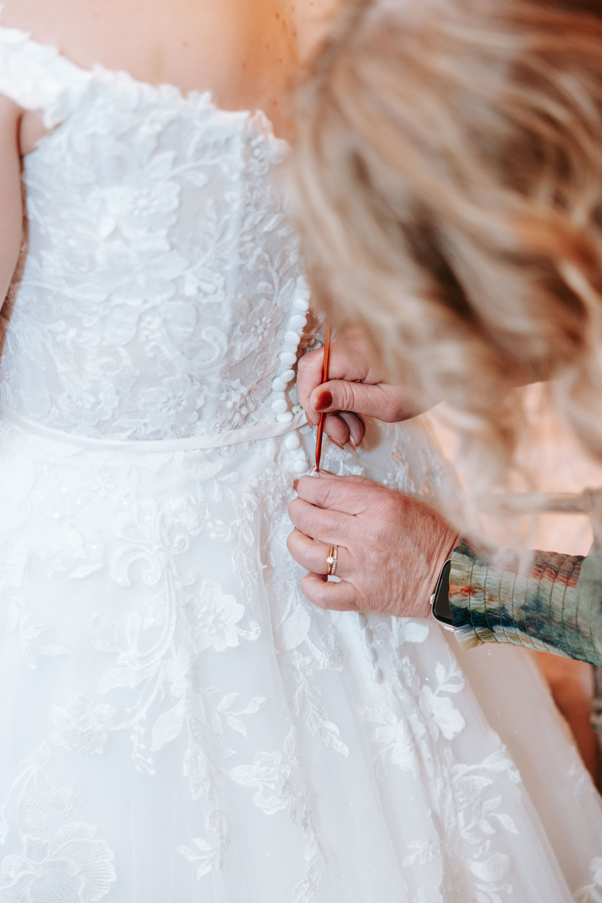 Close-up detail shots of a white lace wedding dress showing delicate embroidered patterns and textural elements.