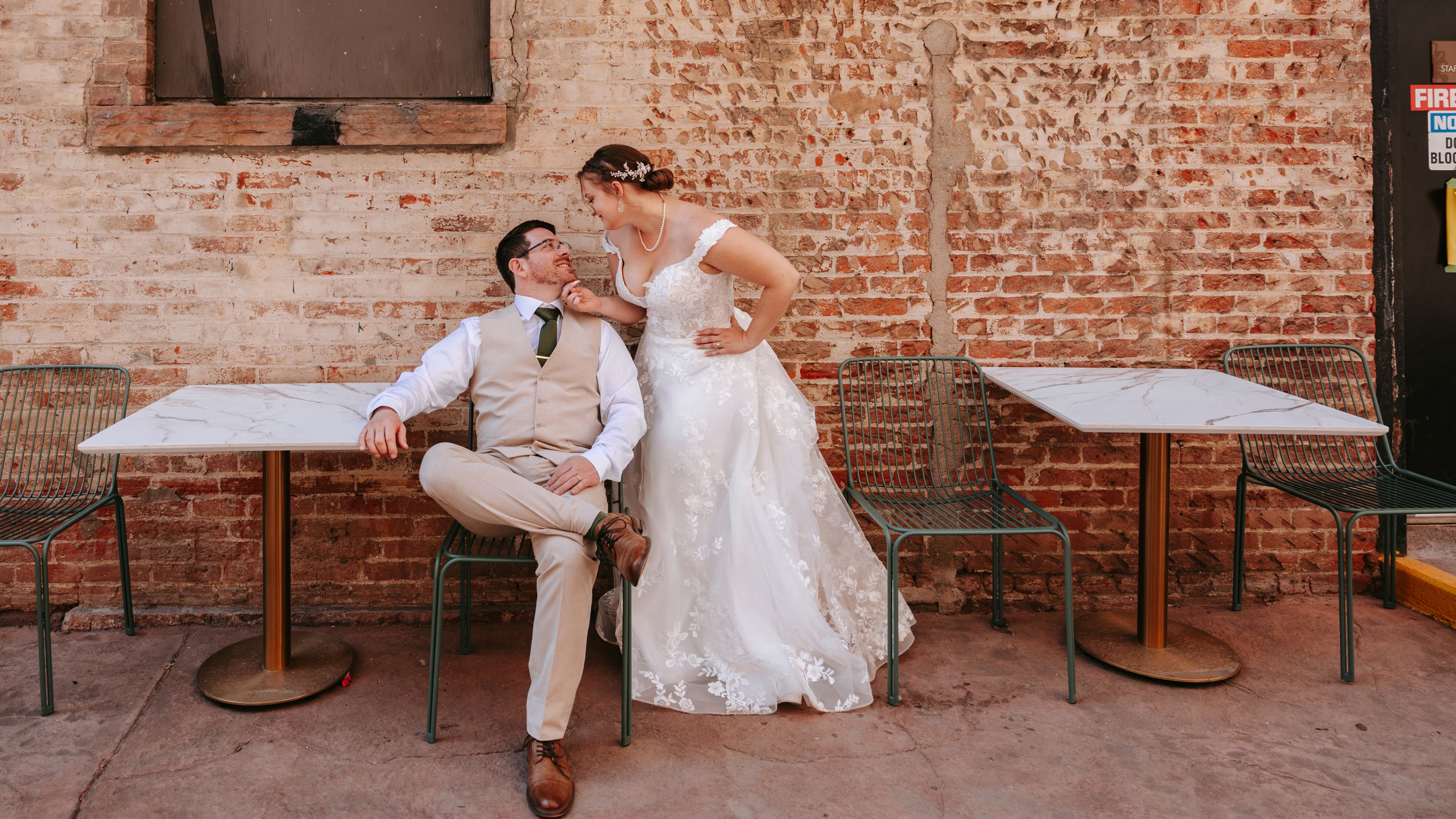 A vintage brick wall setting with couples dancing and celebrating at a rustic wedding venue.