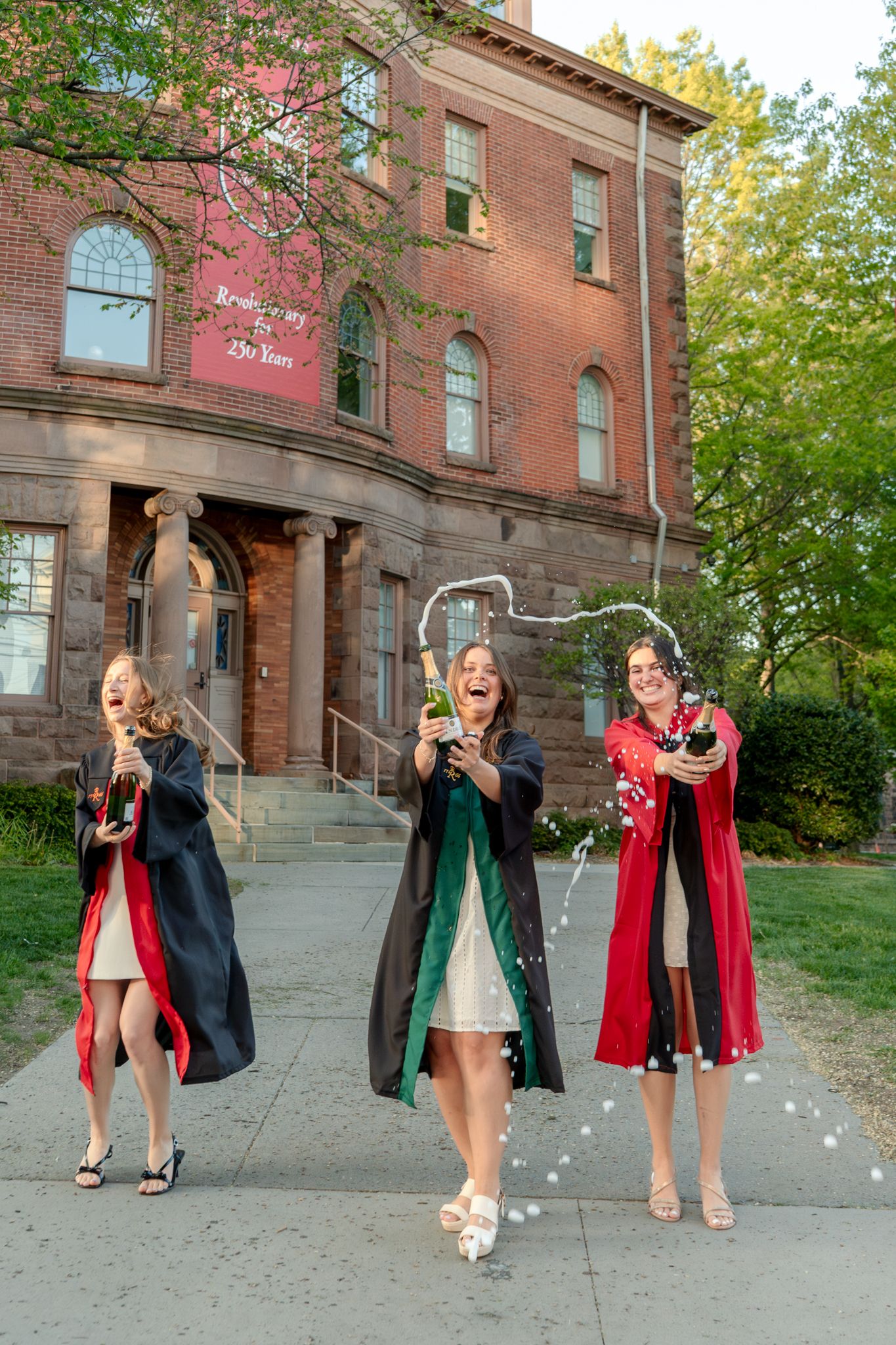 A series of graduation photos showing celebratory poses in front of a brick building.