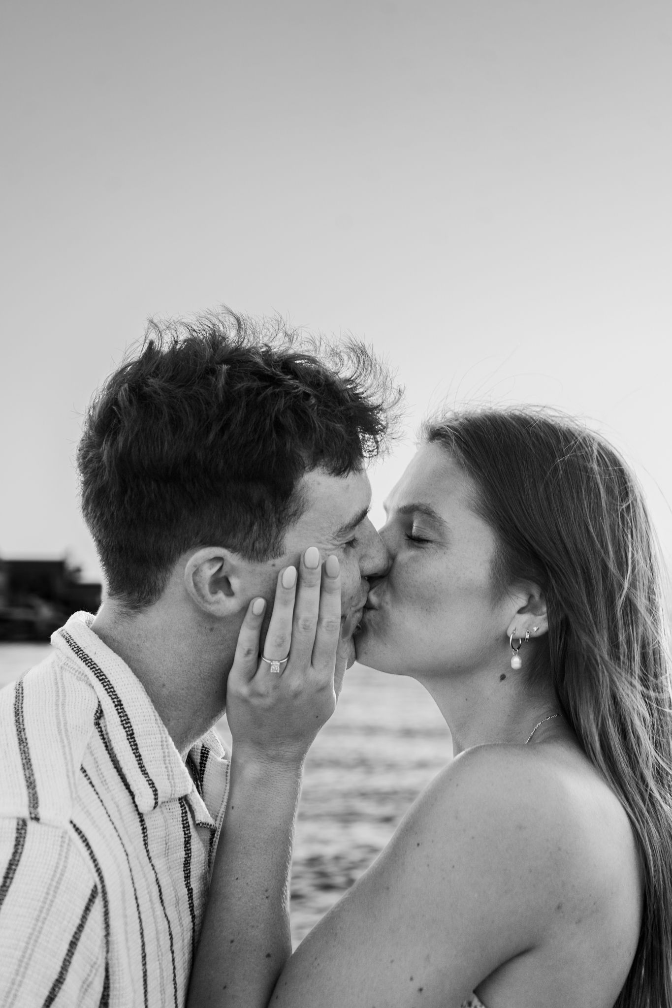 An intimate black and white close-up portrait showing a tender moment.