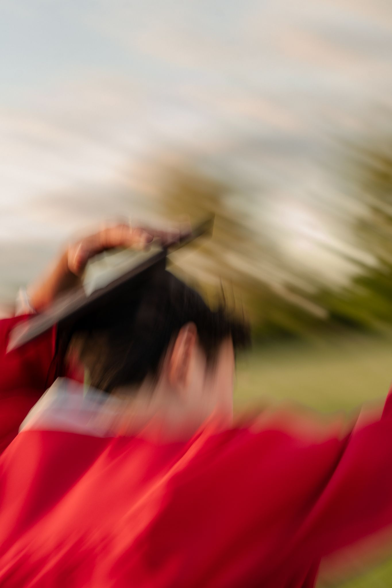Abstract motion blur of graduation caps in red and black colors.