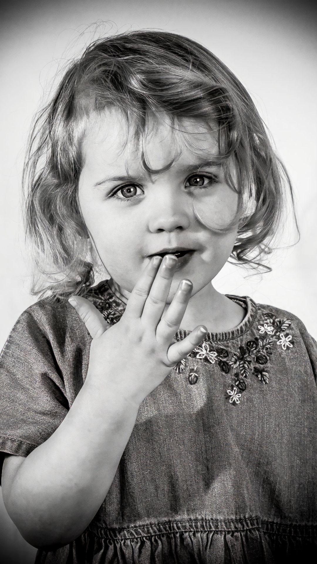 Black and white portrait in dress with floral pattern showing multiple poses and playful expressions.