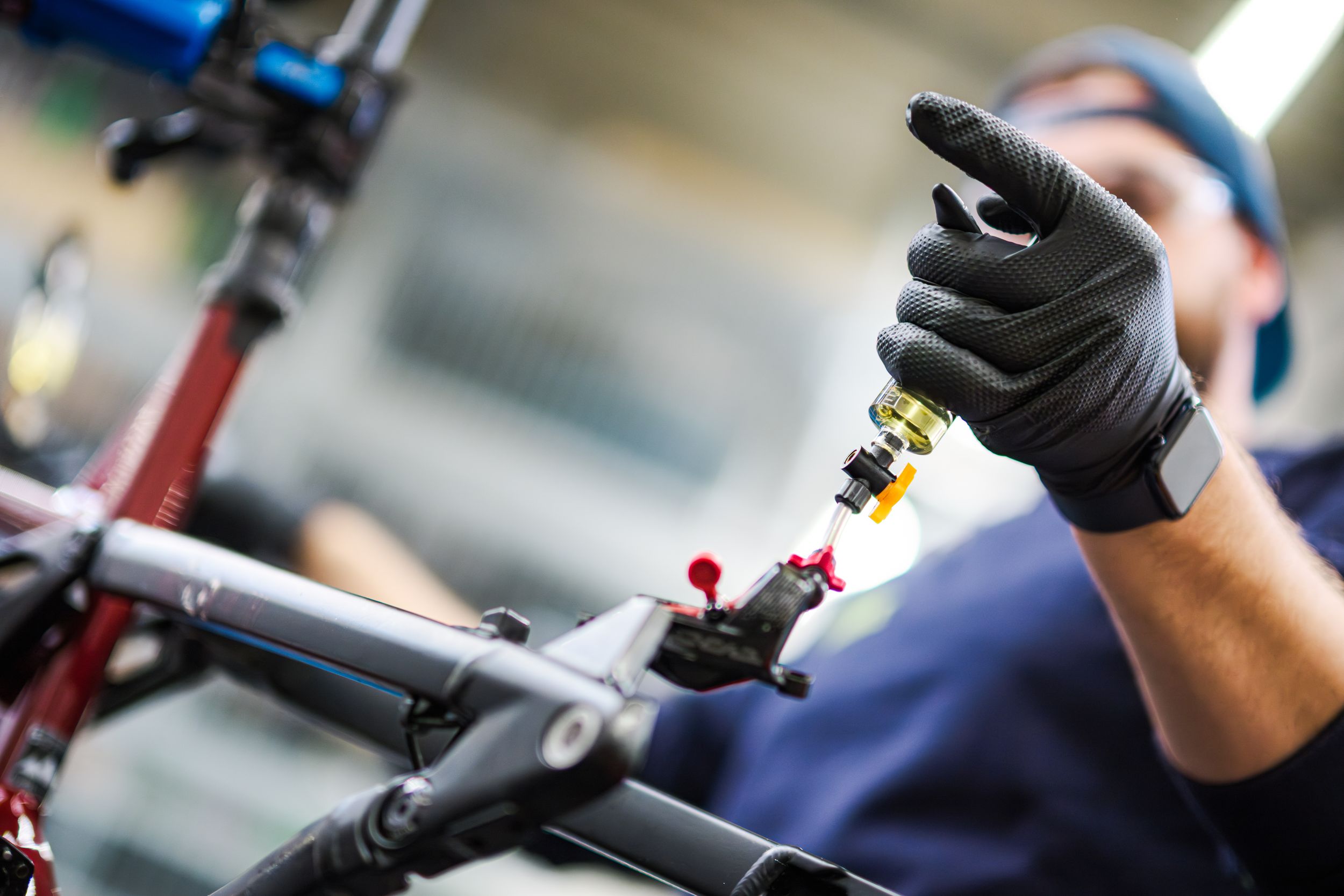 Close-up of hands assembling or repairing bicycle handlebars with tools and cables.