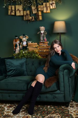 Artistic portraits against dark green wall with fairy lights and hanging decor in moody lighting.