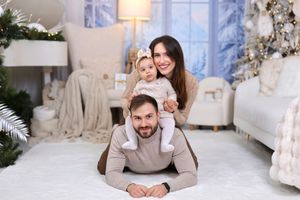 Family enjoying Christmas photos in a cozy white living room setting with festive decorations.