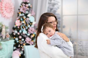 Sweet family moment captured during spring photoshoot with pink floral decor and soft lighting.