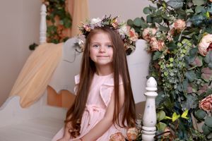 Pink floral studio setup with ornate white furniture and climbing roses creates a romantic backdrop.