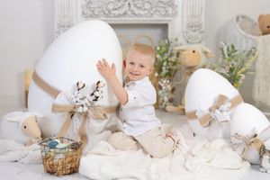 White studio setup with bunny decorations and soft neutral accents creates an Easter theme.
