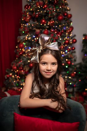 Christmas portrait session with decorated tree and twinkling lights creating festive ambiance.