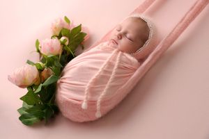 Pink ballet pointe shoes with satin ribbons and delicate peony flowers arranged in a minimalist composition.