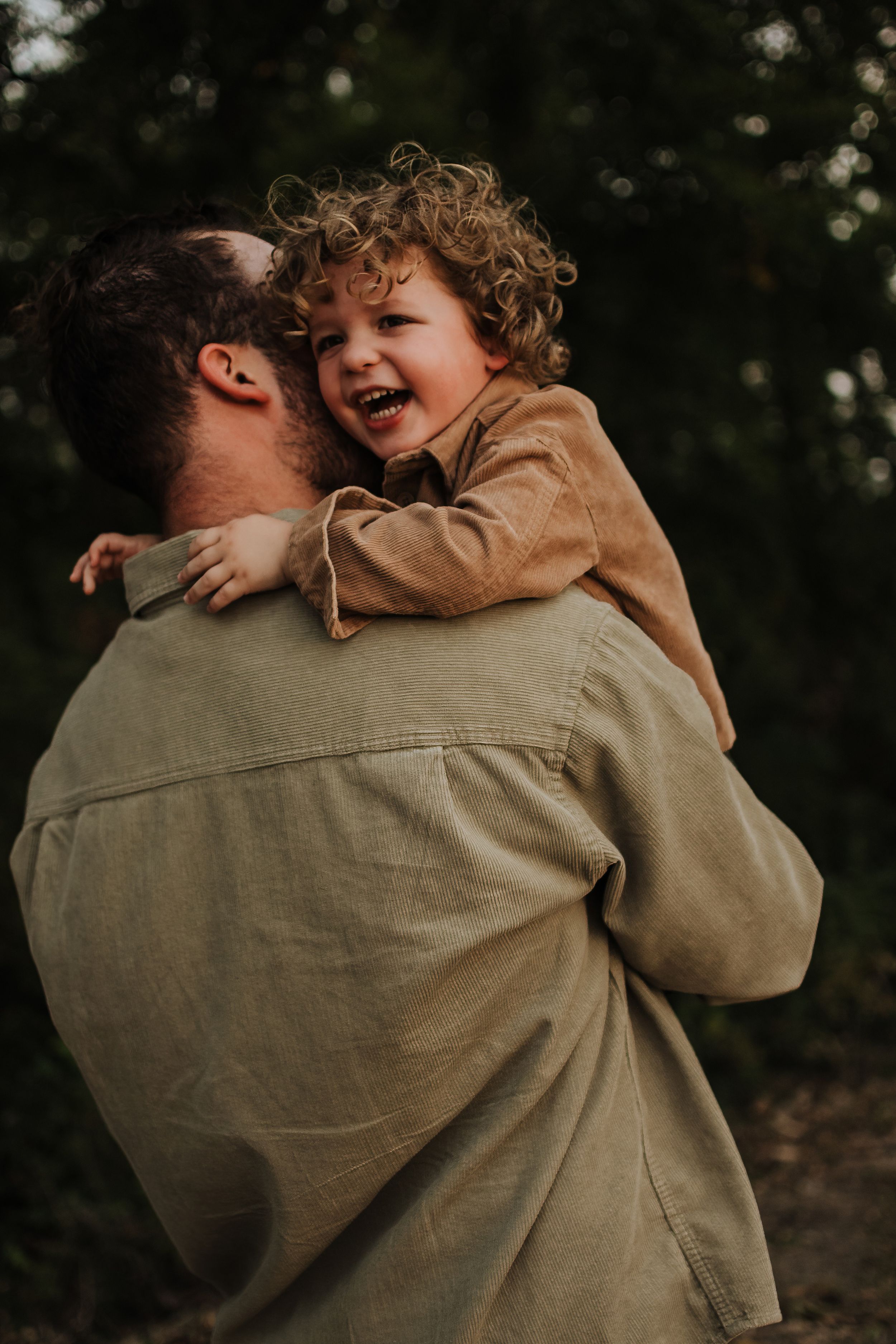 Pure joy captured in a candid moment of laughter and embrace outdoors.