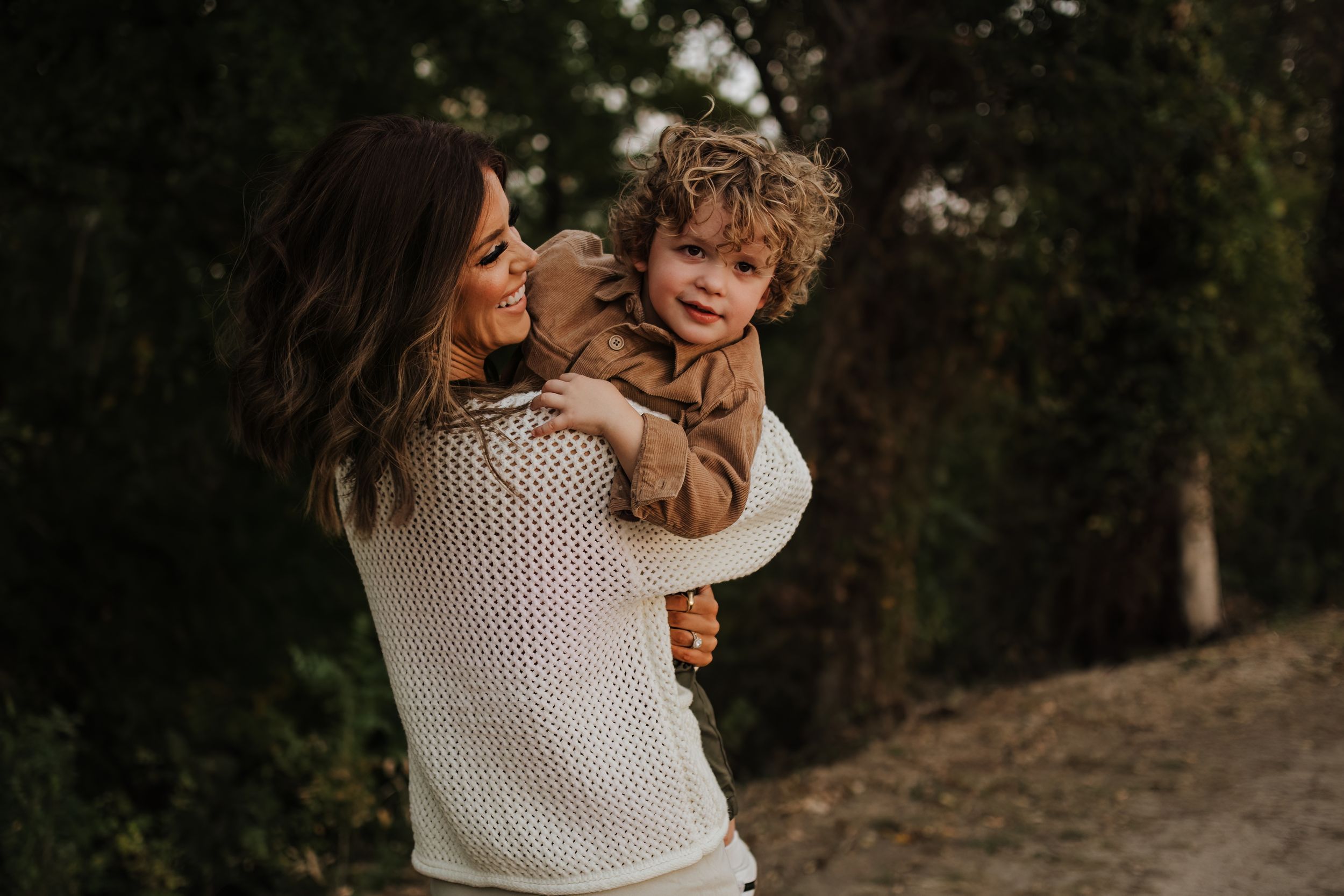 Sweet candid moment of embracing and laughter in a natural outdoor setting.